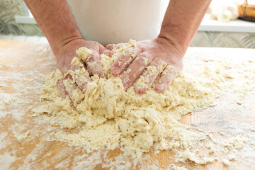 men's hands crumple the dough. Preparation of dough for dumplings.