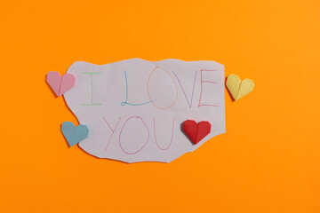 Origami hearts made with colored paper for congratulations on Valentine's Day for couples in love, on yellow background