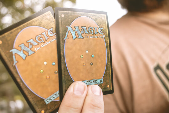 Magic: The Gathering. Homem segurando cartas do jogo de estratégia Magic: The Gathering.