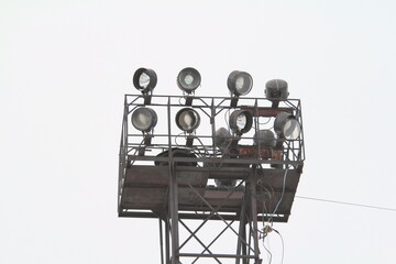 Metal construction with spotlights on top on cloud sky background