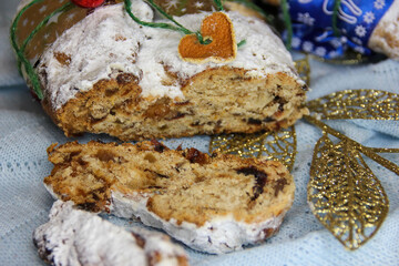 Christmas Stollen and cookies with apple mulled wine and Christmas lights. Traditional Sweet Fruit Loaf with icing sugar.