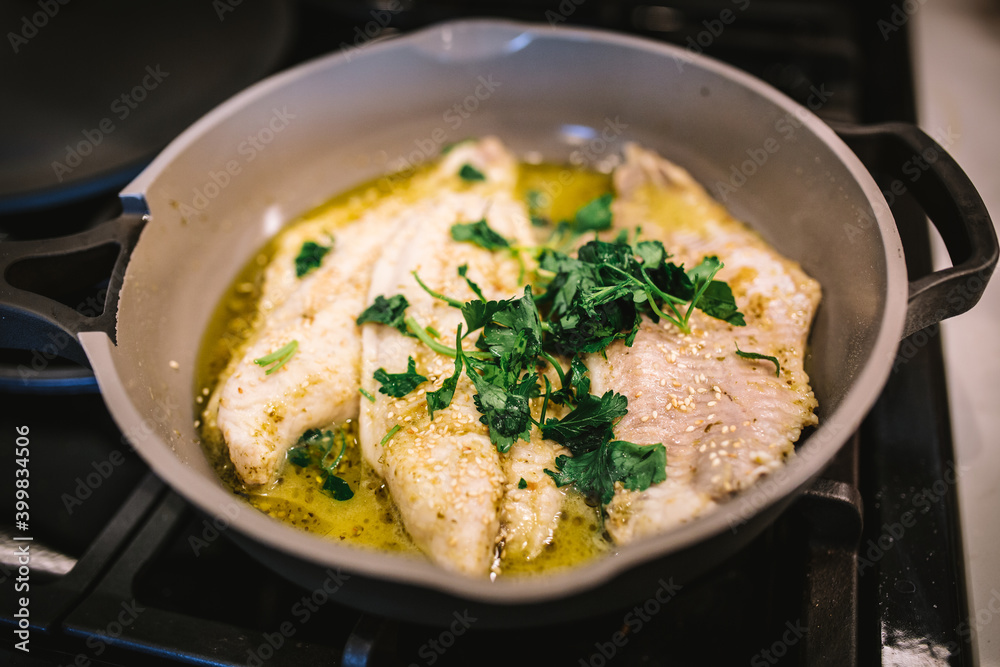 Wall mural fish cooking in ceramic pan with olive oil