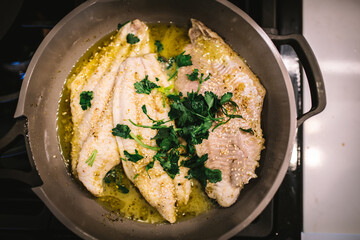 Fish Cooking in Ceramic Pan with Olive Oil