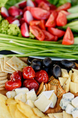 Mix of different snacks and appetizers. Street food plate with set of various kind snacks: bread spicy crackers, french fries and dip, tomatoes, delicious cheese on dark background. antipasto plate
