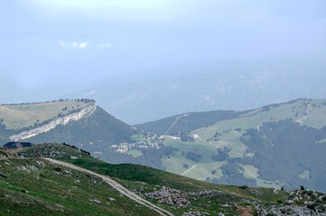Naklejka premium Beautiful view of the peaks of Monte Baldo. Stunning cloudy and panoramic view. Green Pastures in Italian Alps