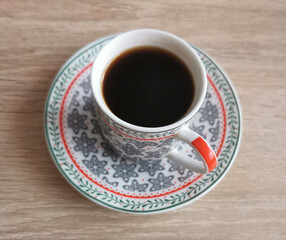 Top view image of a cup of black coffee on a wooden table