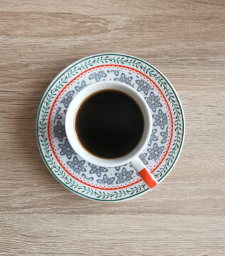 Top view image of a cup of black coffee on a wooden table