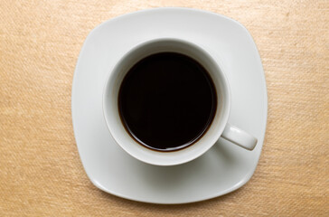 Top view of black coffee in white cup isolated on gold background. Clipping path.