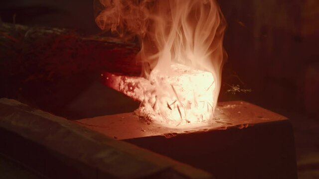 Master Swordsmith adding carbon to a glowing hot ingot then back into coal forge