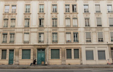 Fototapeta na wymiar façade d'un immeuble ancien avec une dame en train d'entrer