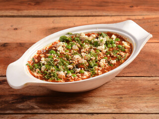 Matar Paneer masala recipe made using cottage cheese, green peas, served over a rustic wooden background, selective focus