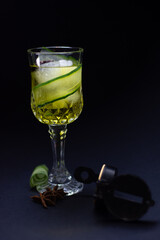 Elegant drink cocktail decorated with cucumber on black background