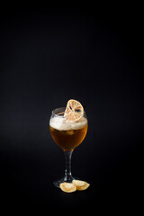 Delicious cocktail with orange on black background