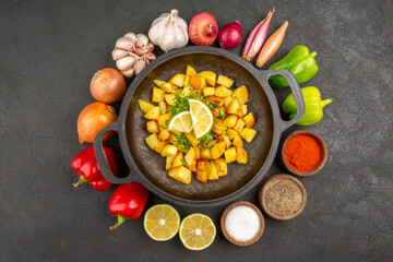 top view tasty fried potatoes inside pan with different seasonings and vegetables on dark desk cuisine meal food calorie pepper