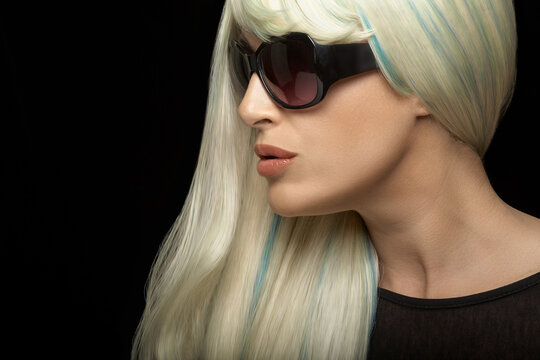 Beautiful woman in sunglasses on black background
