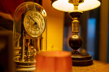 Fototapeta na wymiar Schöner Tisch mit alter Uhr, Lampe, Kerze und Deko