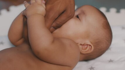 Close up black father tickling tummy of his newborn baby . Fatherhood and family. High quality 4k footage
