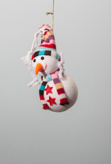 figurilla de árbol de navidad con forma de muñeco de nieve simpático y sonriente suspendido en el aire colgando de un hilo