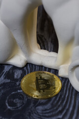 Obraz na płótnie Canvas Bitcoin next to a plaster statue. Close-up shot.