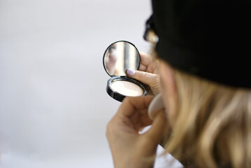 Senior Woman with black hat looking in her mirror. 