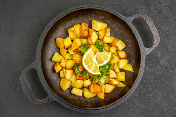 top view tasty fried potatoes inside pan with lemon on dark background cuisine photo color food meal