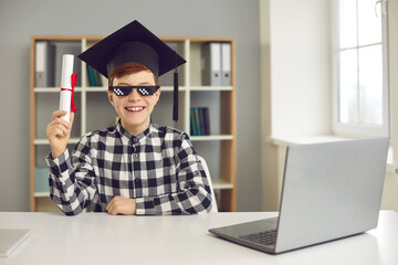 Happy student sitting at desk with laptop and holding course completion certificate