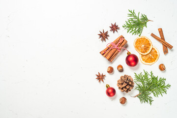 Christmas composition made from natural decorations. Winter tree, spices, cones and nuts at white marble background. Flat lay image with copy space.