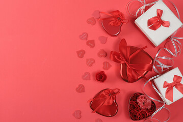 The concept of Valentine's Day or Women's Day. Greeting card, hearts and gift boxes on a red background, place for text, banner, Happy holiday, congratulations, birthday, selective focus