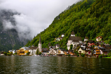 Hallstatt, Austria.  View to Hallstattersee Lake and  the peaks of the Alps. Ancient houses on the shore of the lake with a chapel. Tourism in Austria. The Alps are a popular tourist destination. 