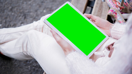 Woman holding a tablet in the park