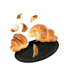 Fresh croissant divided in two and a black plate.