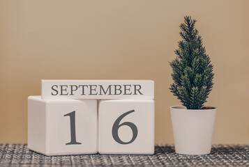 Desk calendar for use in different ideas. Autumn month - September and the number on the cubes 16. Calendar of holidays on a beige solid background.