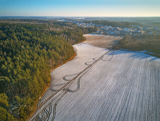 Winter Agricultural field under snow. Aerial scene. December Rural landscape.
