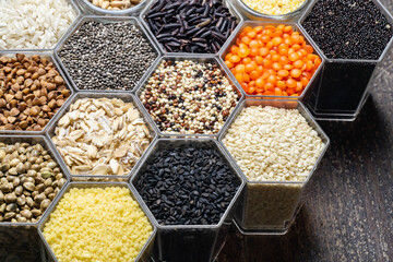 Food background of various cereals and grains in the hexagonal honeycomb jars