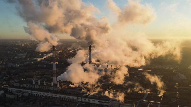 Polluting Factory at Dawn. Atmospheric air pollution from industrial smoke and dioxide. Industry pipes pollute the atmosphere with smoke