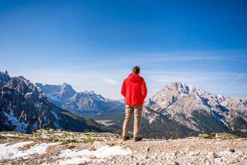 Naklejka premium male hiker admiring the panorama view on mountains