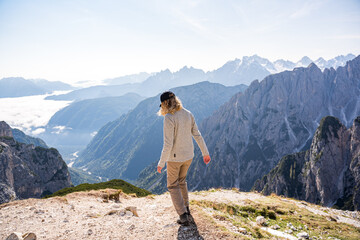 young woman walking to the edge of a mountain