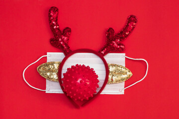 Medical face mask with deer antlers on red background. concept of christmas in face of COVID-19 pandemic