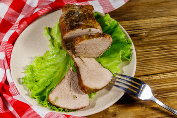 Tasty baked pork with spices on a wooden table