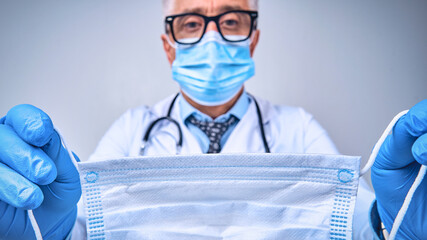 Adult doctor in mask and uniform taking care for patients