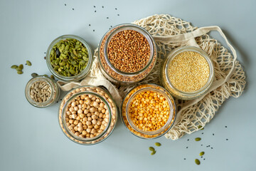 Organic bio bulk products in zero waste shop. Foods storage in kitchen at low waste lifestyle. Cereals and grains in glass jars on table. Eco friendly shopping in plastic free grocery store.
