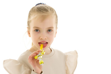 Cute little girl licks a candy.