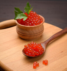 fresh grainy red chum salmon caviar in a wooden spoon