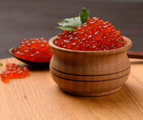 fresh grainy red chum salmon caviar in a wooden plate, delicious and healthy food