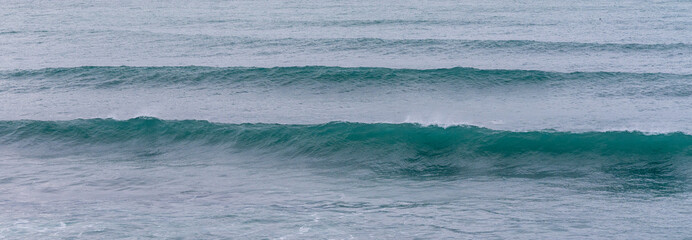 big glassy waves from a ground swell at the Praia do Portinho beach in Peniche