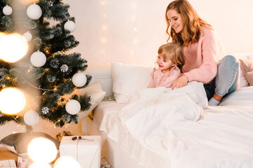 Little girl's christmas morning. Mom woke up her daughter to give new year gifts