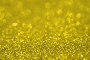 Illuminating Pantone Color Of The Year 2021. Abstract festive bokeh background with shining defocus sparkles. Blurred glitters shimmering dust macro close up, copy space for text logo