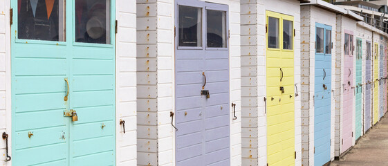 Row of beach huts at Lyme Regis, Dorset, UK. Pastel colours.