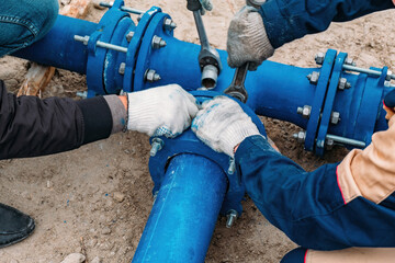 Workers installing water supply pipeline system, close up