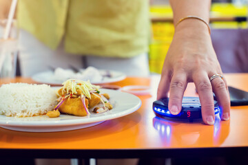 Wireless queue caller machine in hand of customer with food. Queue paging wireless calling System...